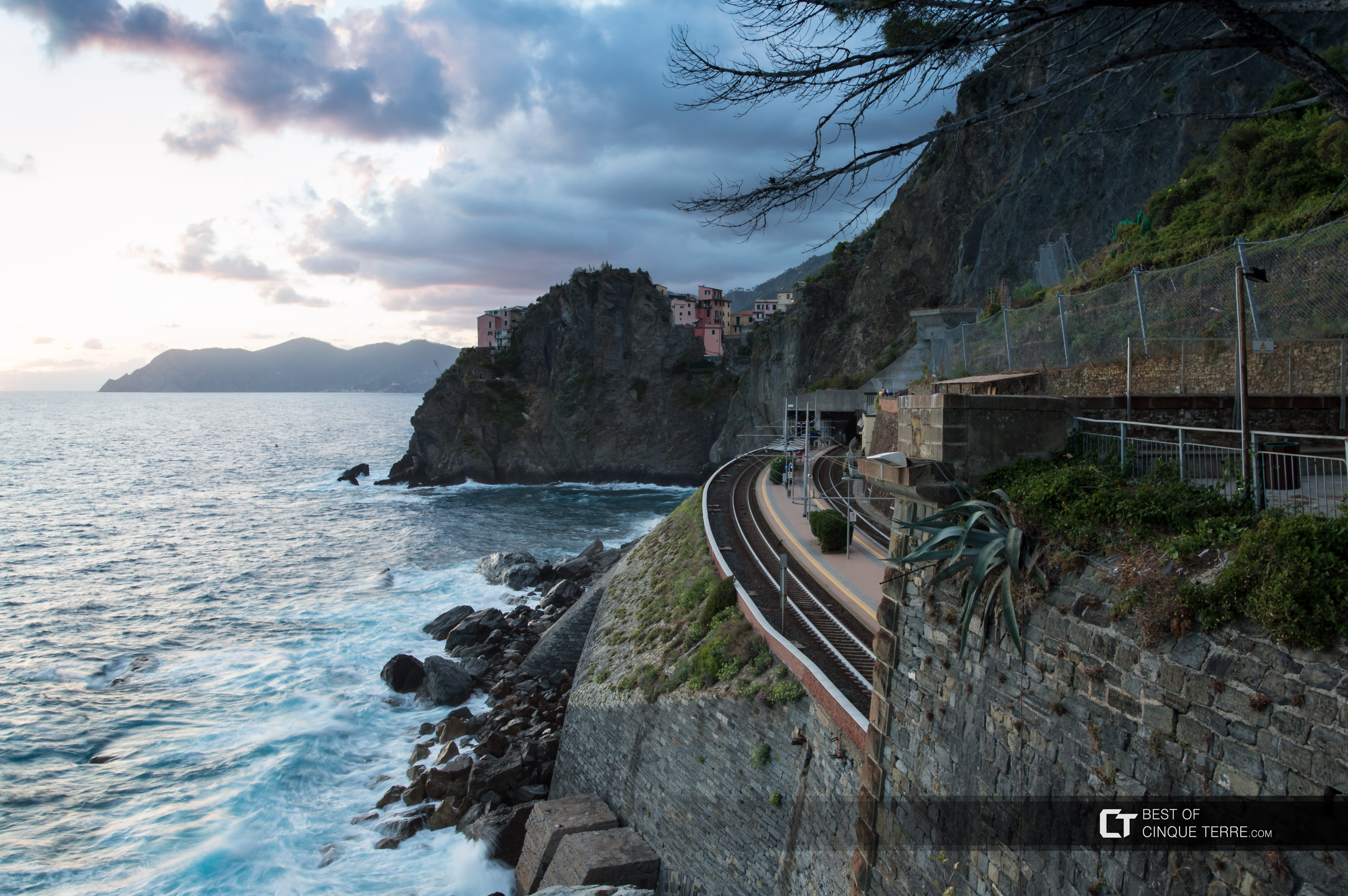 Vista da estação e da vila atrás da rocha da Via dell'Amore, Manarola, Cinque Terre, Itália